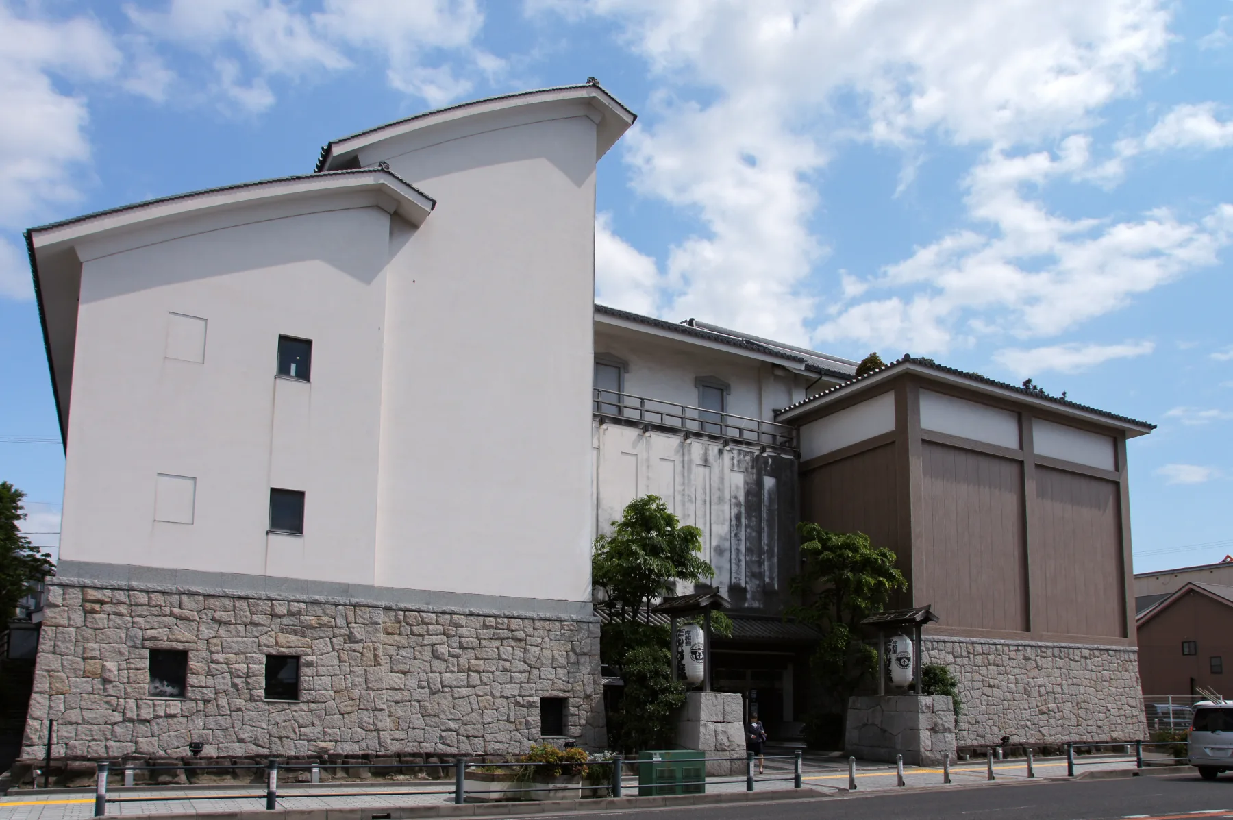 The white-walled exterior of the Kishiwada Danjiri Kaikan festival museum under a blue sky