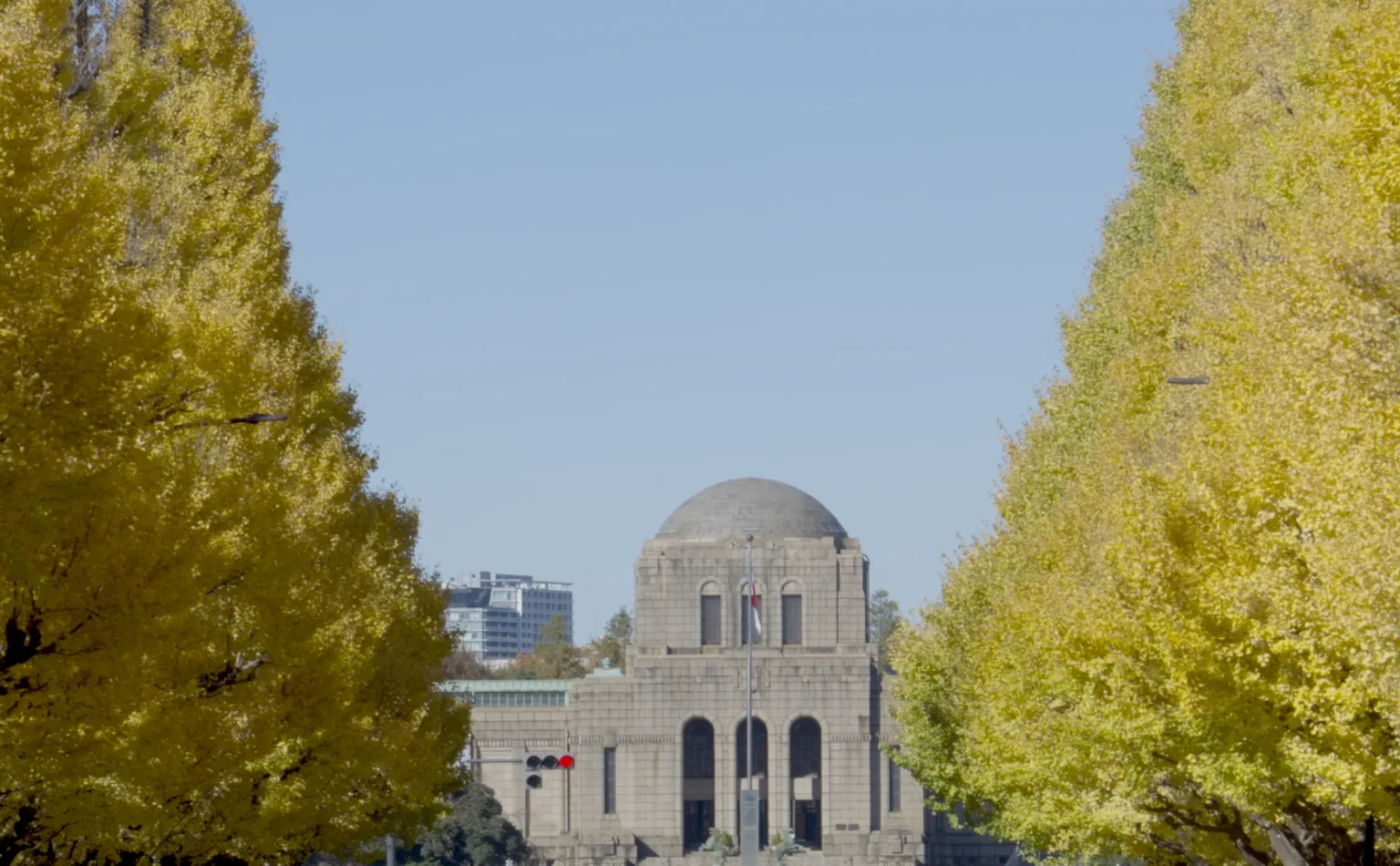 The ginkgo avenue at Meiji Jingu Gaien in peak autumn gold, the trees closing in on the domed Meiji Memorial Picture Gallery, Tokyo