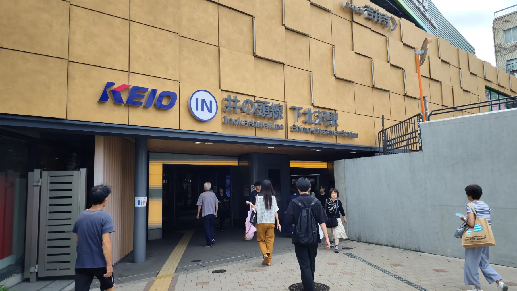 The Keio Inokashira Line entrance at Shimo-Kitazawa Station, with the Keio logo, a circular IN sign and the station name in Japanese and English above the doorway.