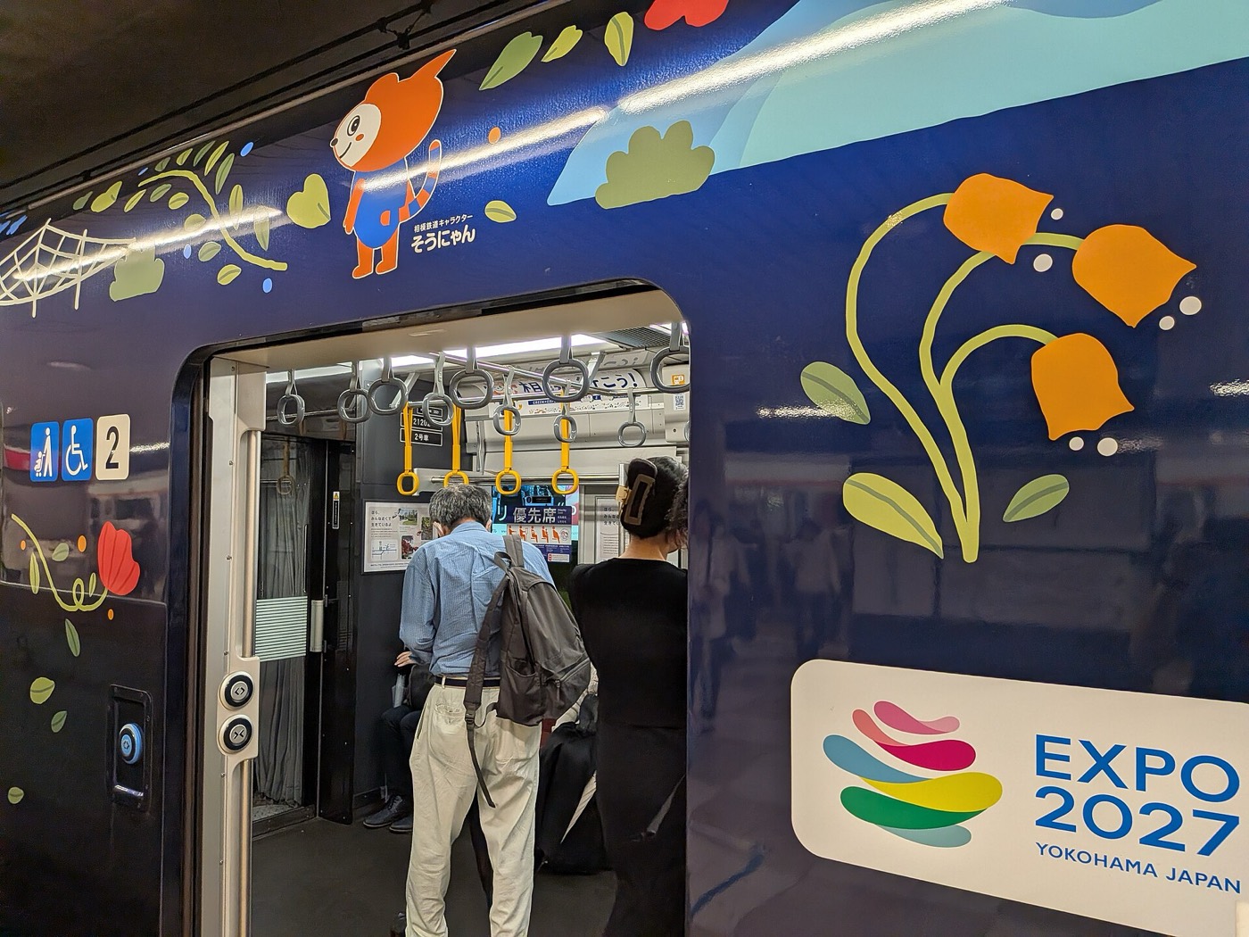Sotetsu train wrapped in GREEN×EXPO 2027 livery with passengers boarding