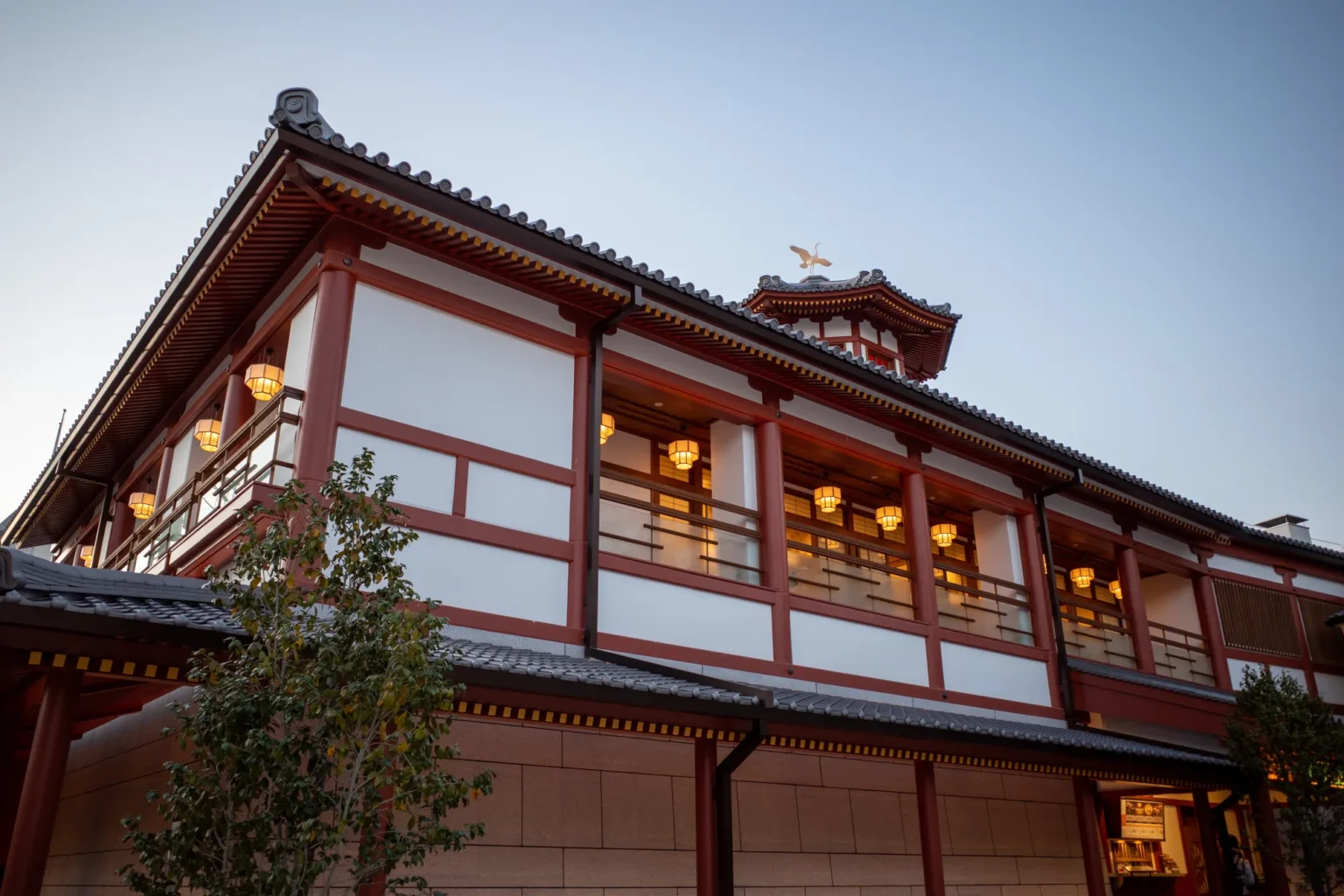 Dogo Onsen Asuka-no-Yu bathhouse with lit windows in the evening, Matsuyama