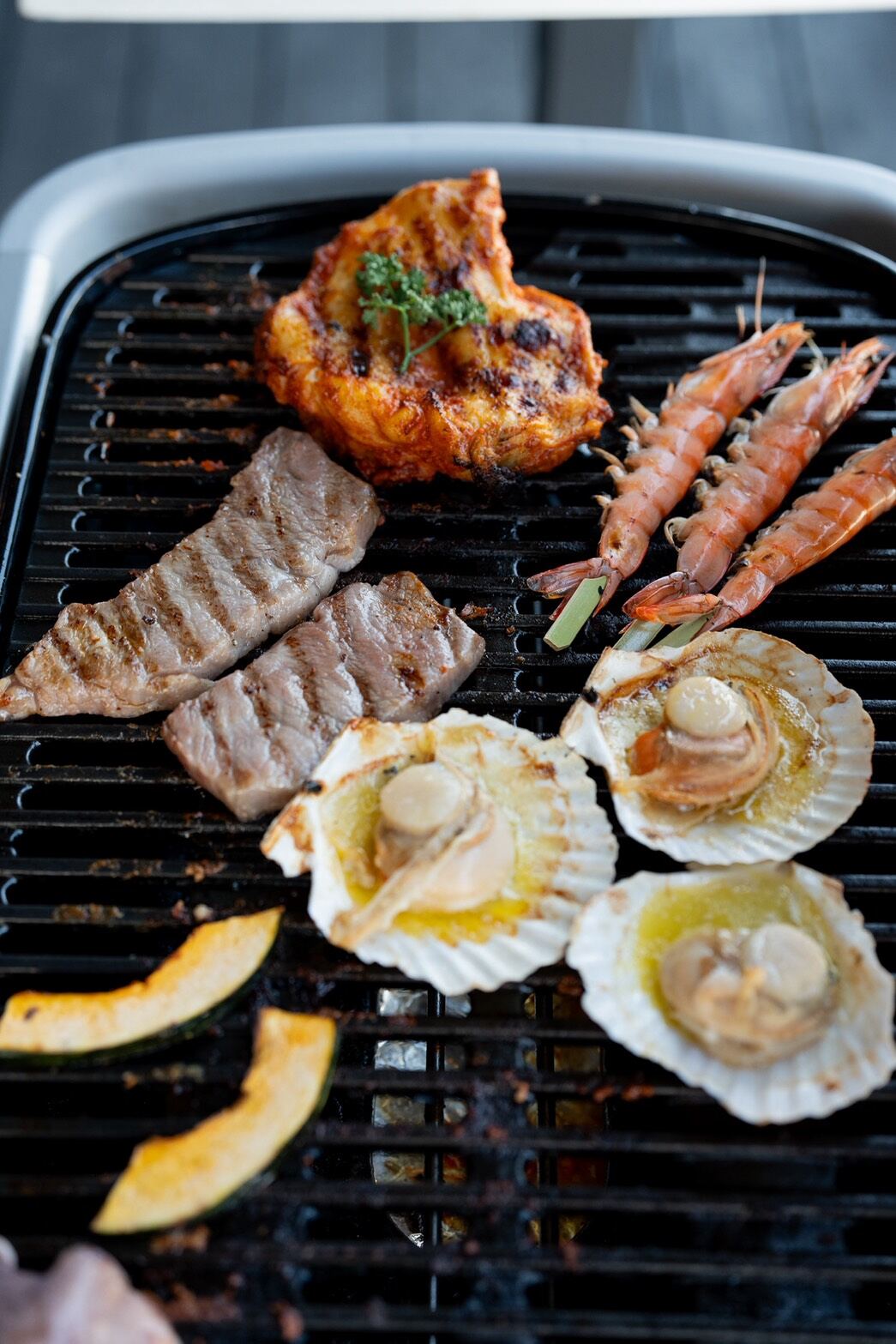 Prawns, scallops and chicken on a table-top grill