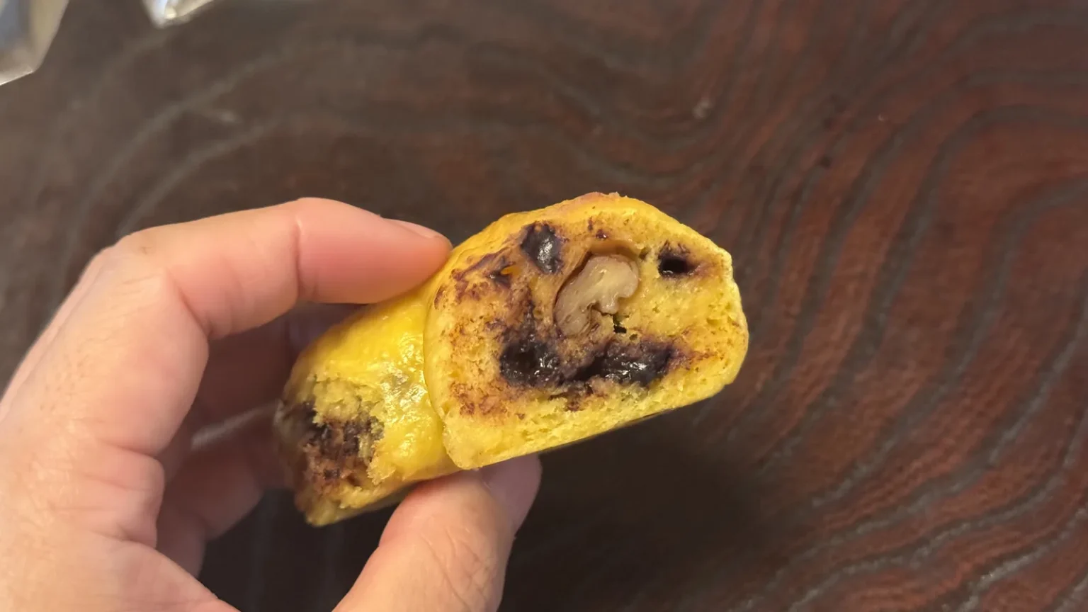 A bagel cut open, showing yellow dough and a dark filling