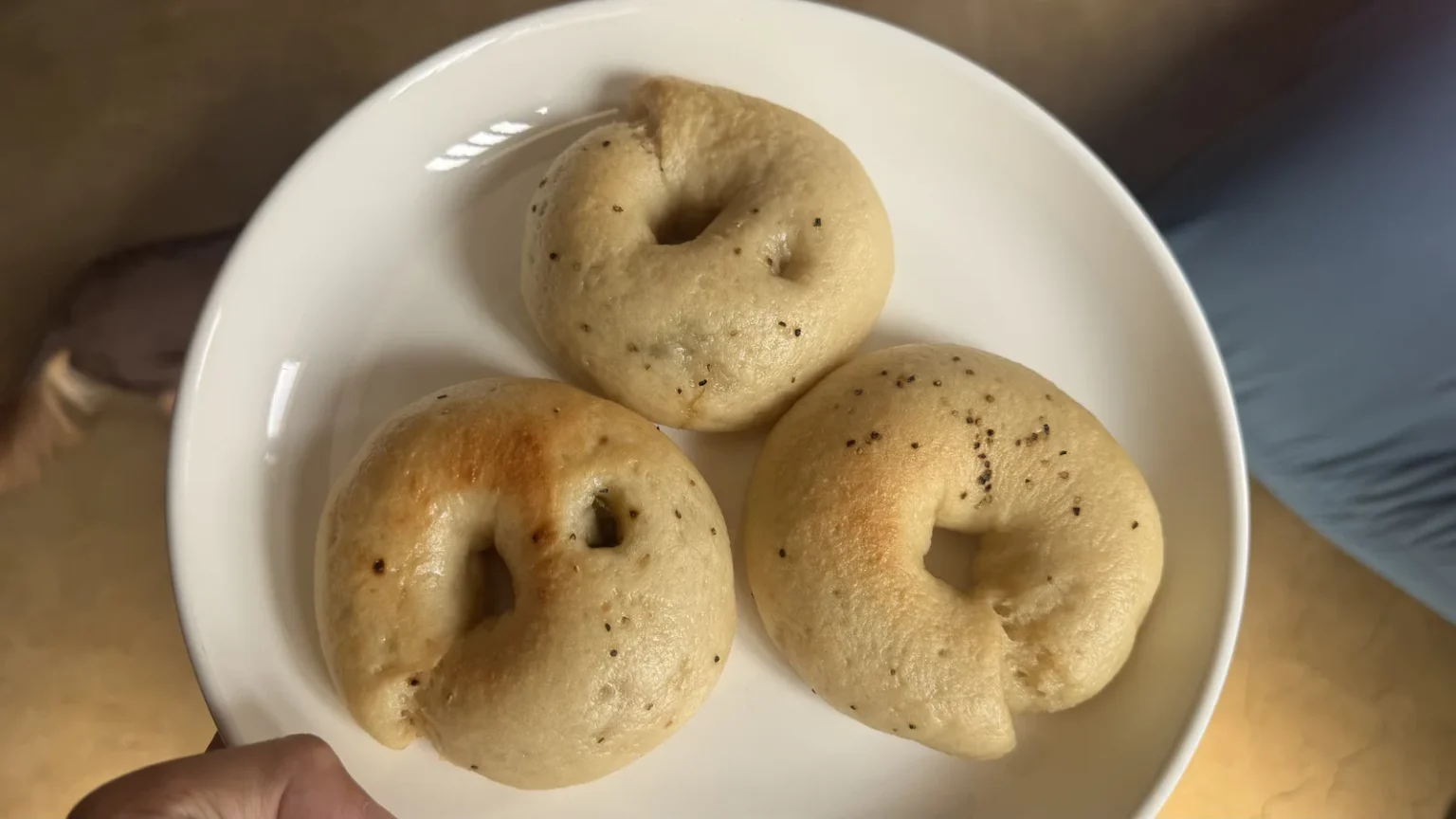 Three rice-flour bagels with dark specks on a white plate