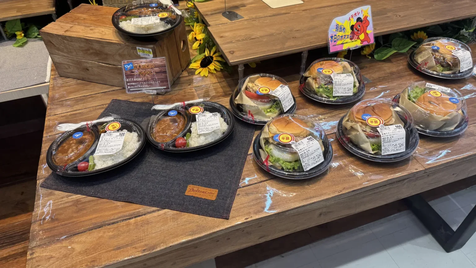 Ready-made meals in plastic containers on a wooden table, including hashed beef rice and burgers