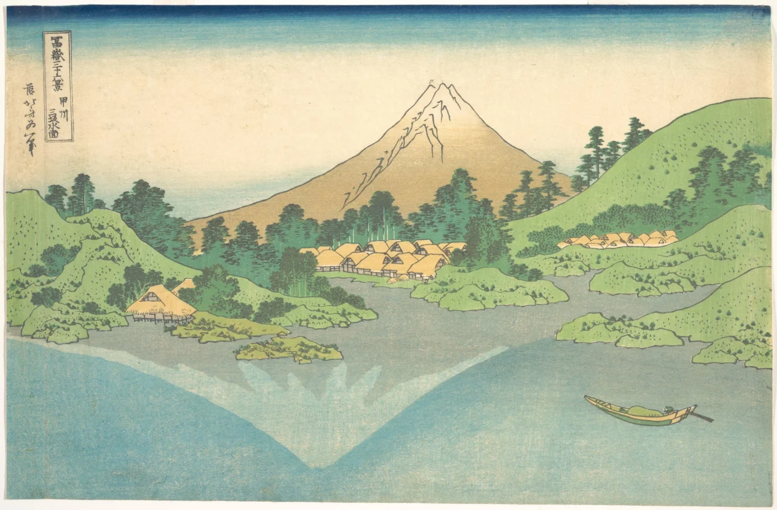 Woodblock print of a calm grey-blue lake with thatched villages and green wooded hills on the far shore. Behind them rises Mount Fuji in summer, red-brown with a few streaks of snow at the top, while its reflection in the water is pale and fully snow-covered, and sits to the left of the real peak. A small boat with one figure crosses the lake at lower right.