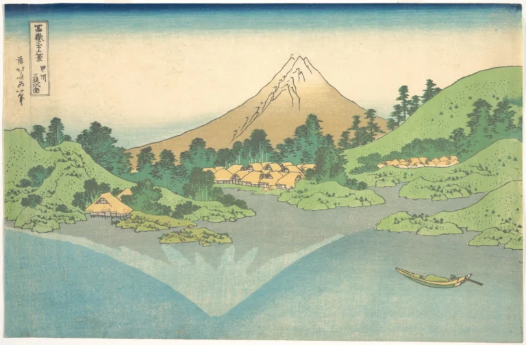 Woodblock print of a calm grey-blue lake with thatched villages and green wooded hills on the far shore. Behind them rises Mount Fuji in summer, red-brown with a few streaks of snow at the top, while its reflection in the water is pale and fully snow-covered, and sits to the left of the real peak. A small boat with one figure crosses the lake at lower right.