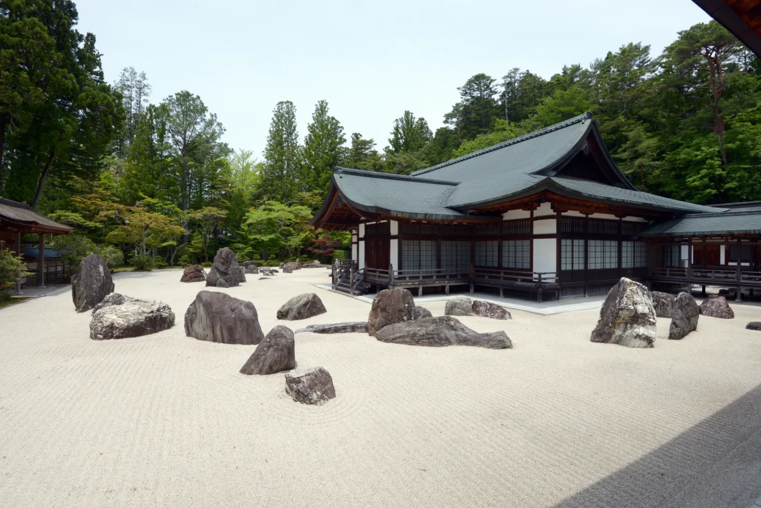 The Banryutei rock garden at Kongobu-ji, with groups of grey granite stones set in raked white sand in front of a temple building