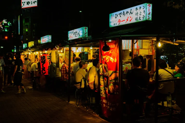 A row of lit yatai food stalls at night in Nakasu, Fukuoka