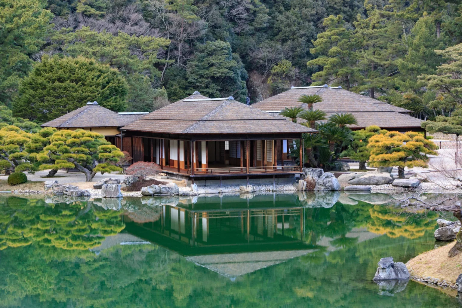 The Kikugetsutei teahouse on the edge of the South Pond in Ritsurin Garden, reflected in the water