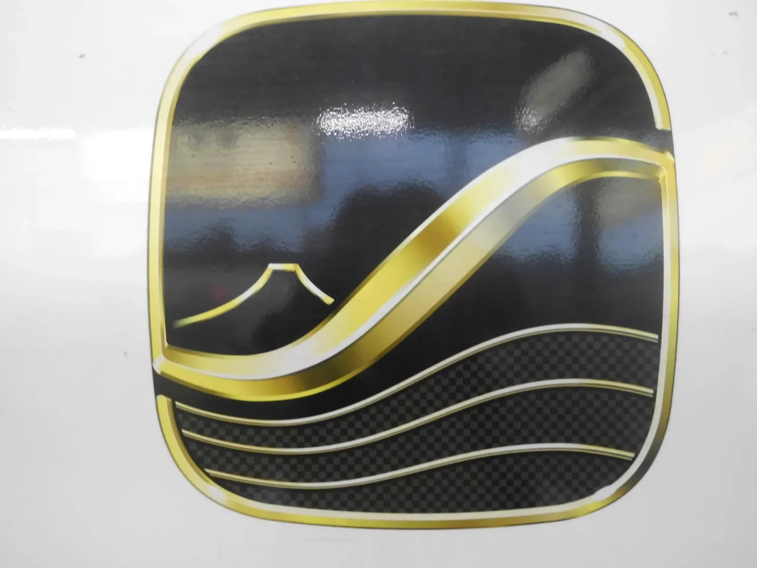 The Supreme Class logo on the white side of an N700S train: a gold-framed black square with a gold S-shaped curve, a small outline of Mount Fuji and wavy lines for the sea