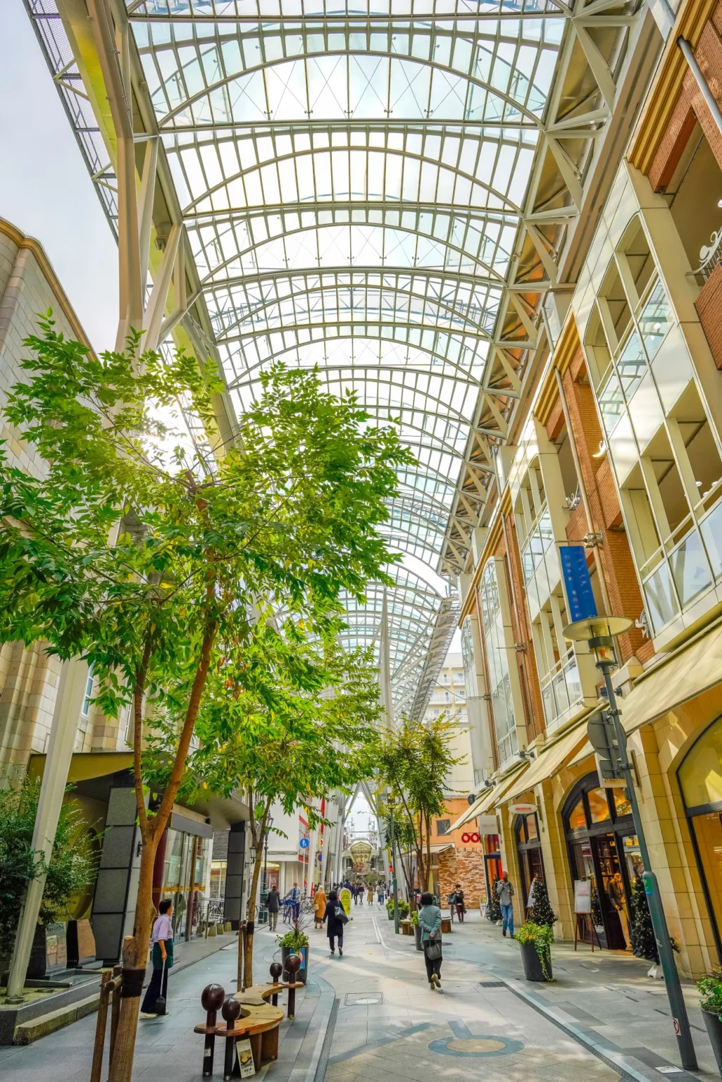 People walking under the glass roof of a covered shopping street in central Takamatsu