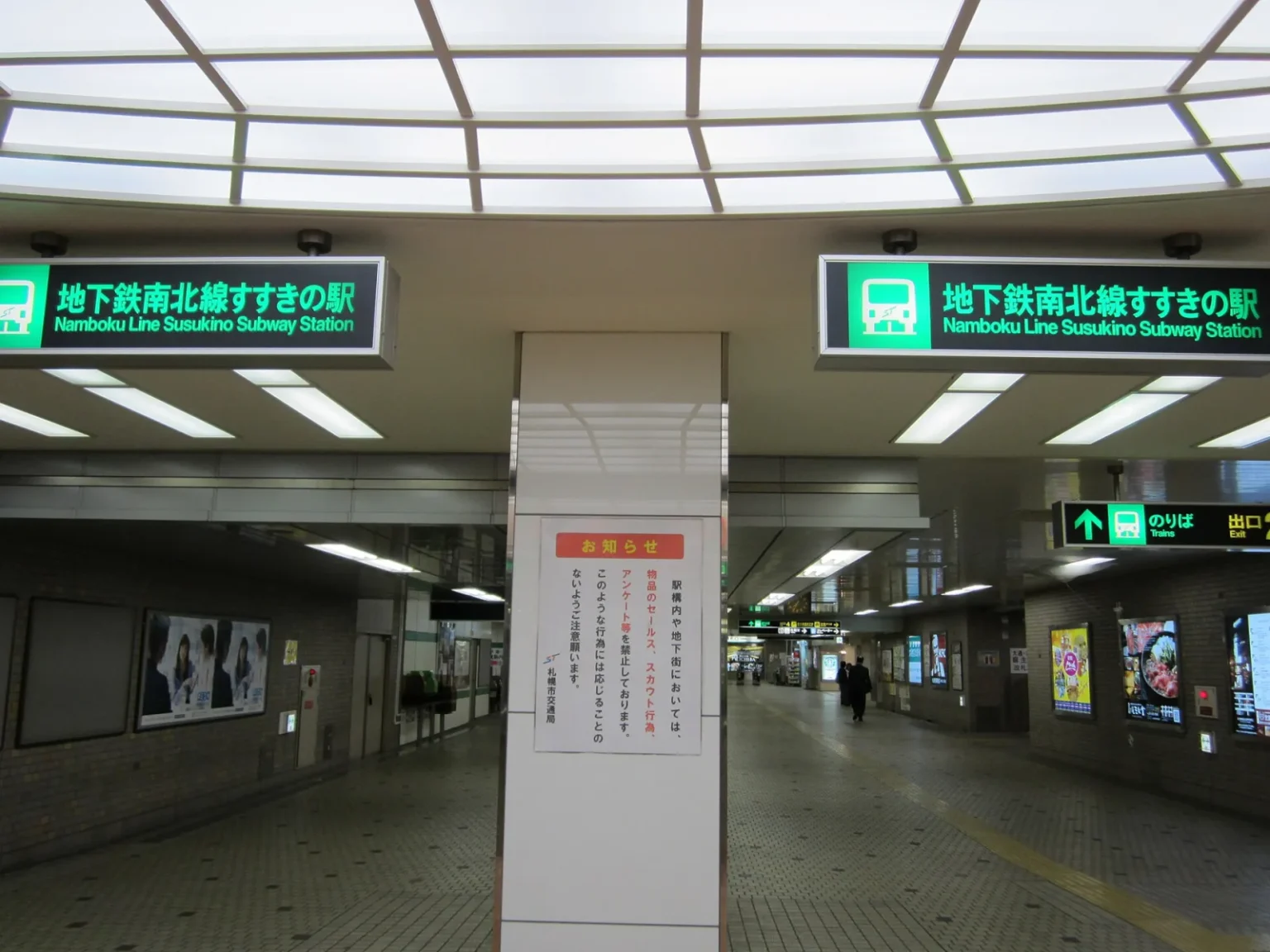 The concourse of Susukino subway station on the Namboku Line, with bilingual signs and a tiled underground passage