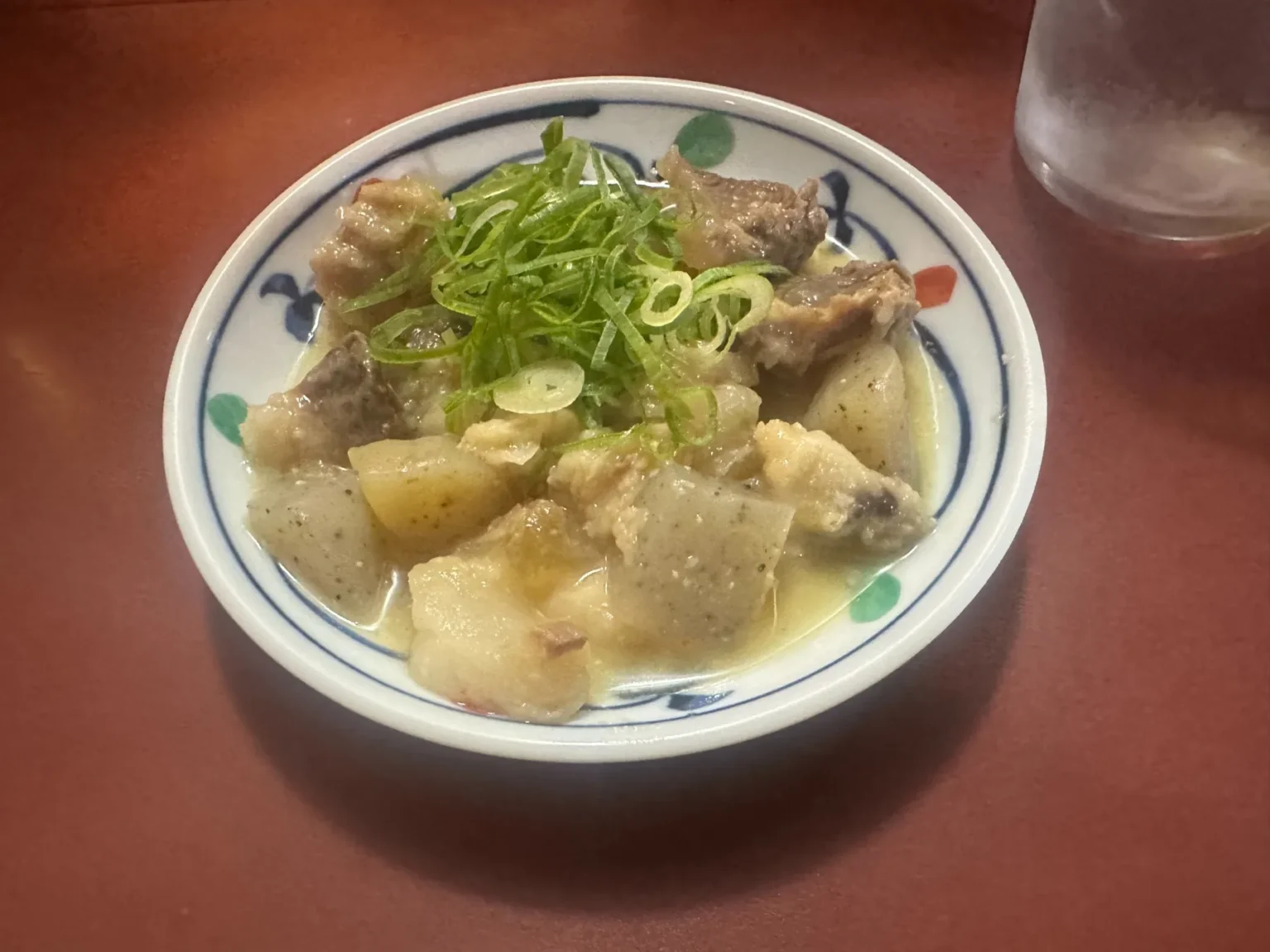 A small bowl of stewed food topped with spring onion at a Nakasu yatai